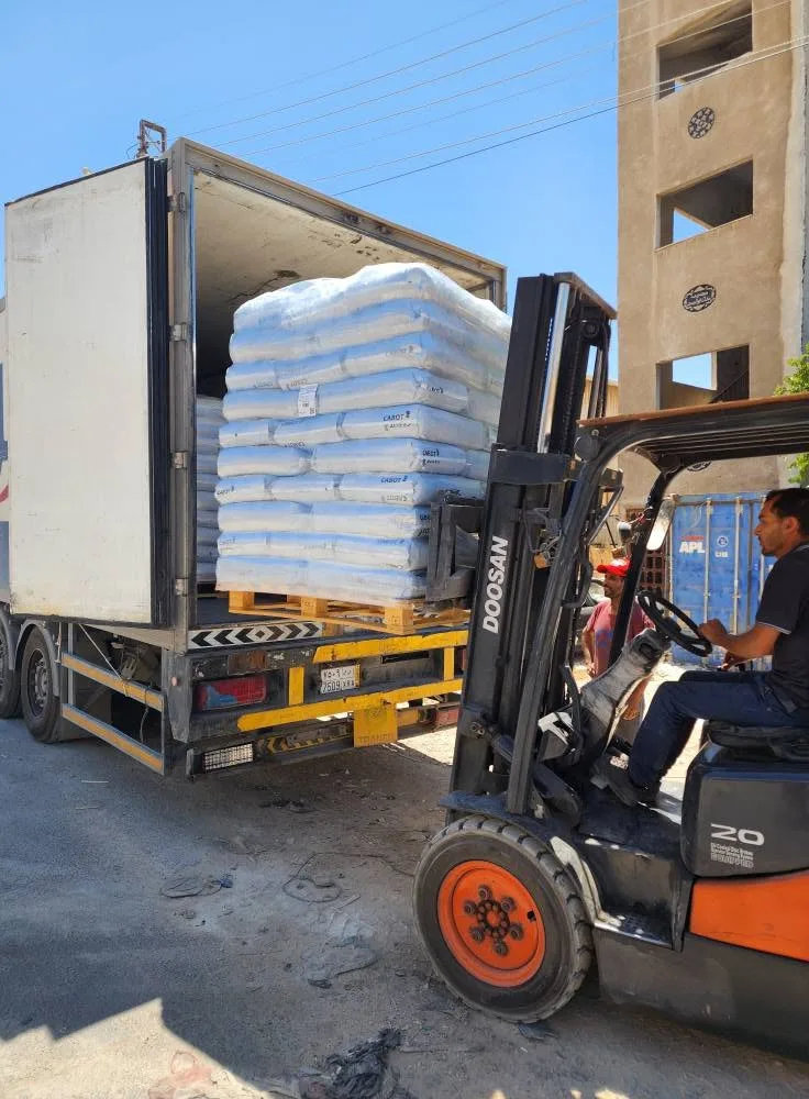 Forklift loading pallets of bags into a truck
